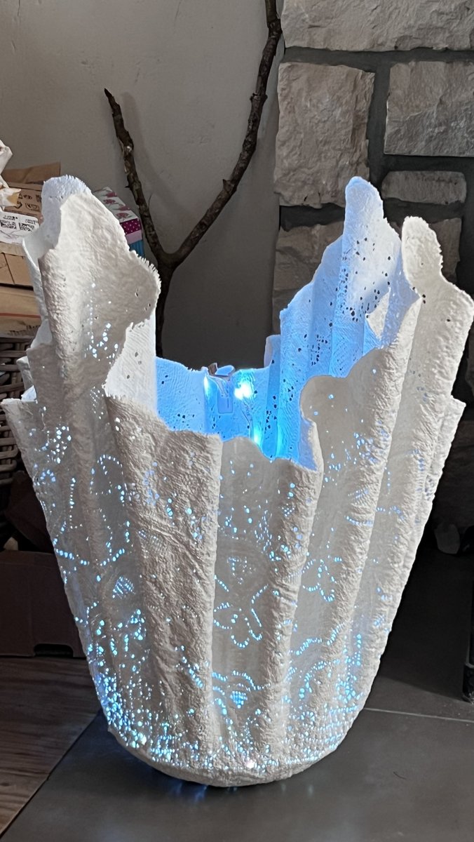 Profil multipotentiel et business : la Dentelle de Bruges Lamp illuminée en bleu, sculpture lumineuse née d'une nappe en dentelle